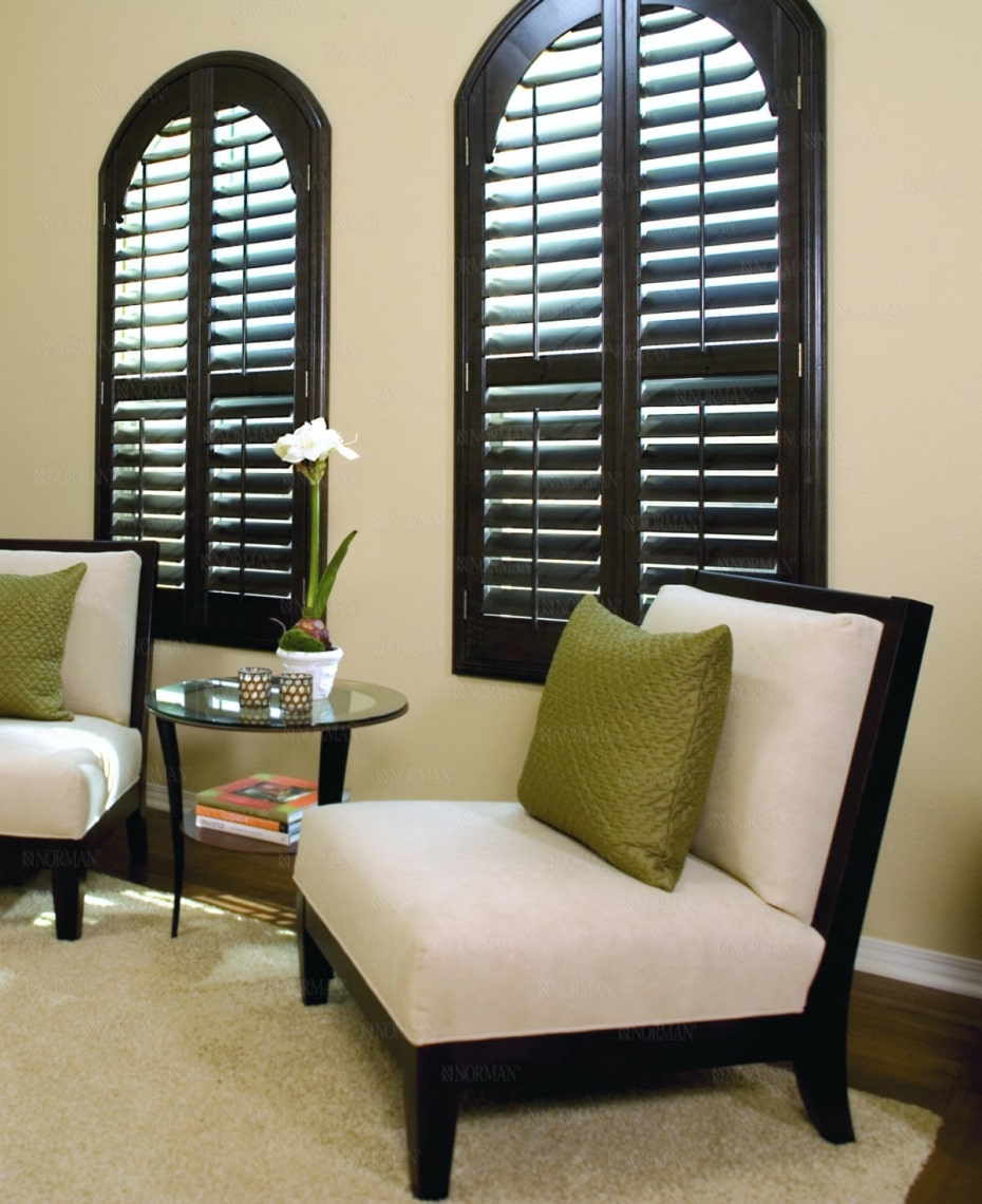 Custom plantation shutters with dark wood and top arch